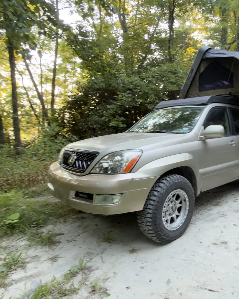 Ginny on a sandy trail with the rooftop tent open